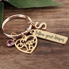 a keychain that says follow your dreams with a heart and tree on it