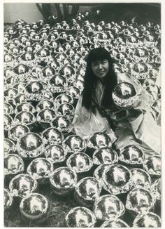 a woman kneeling on the ground in front of many bowls