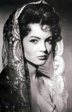 an old black and white photo of a woman wearing a veil