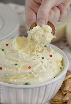 a person dipping something into a white bowl