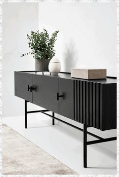 a black and white sideboard with two vases sitting on it's sides