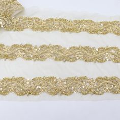 three gold sequin trims on white fabric