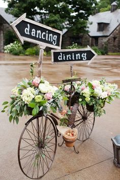 a bicycle with flowers and signs attached to it's front wheel that says dancing