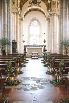 an image of a church with candles on the pews and flowers in front of it