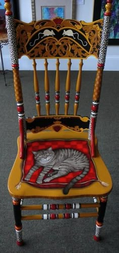 a wooden rocking chair with a cat on the seat