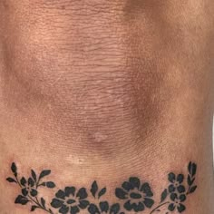 a close up of a tattoo on the side of a person's stomach with flowers