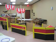 an empty classroom is decorated in red, yellow and black with decorations hanging from the ceiling