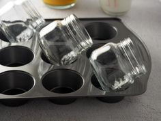 there are four glass cups in the muffin tins on the counter next to some orange juice