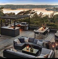 an outdoor living area with patio furniture and fire pit on the deck, overlooking water