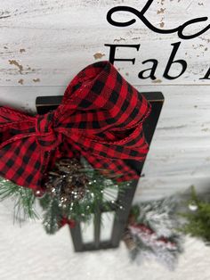 a red and black bow hanging from the side of a sign