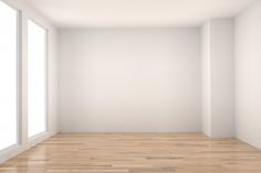 an empty room with white walls and wooden floors