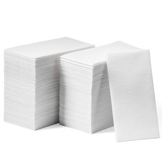 a stack of white napkins sitting next to each other on top of a table