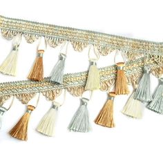 several tassels are hanging from the side of a white wall with gold trim