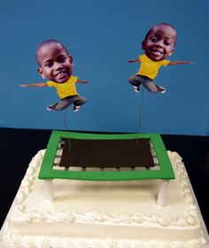 there is a cake with two pictures of babies on it and one has an upside down table