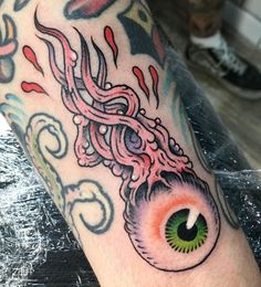 a close up of a person's arm with an eye and tentacles on it