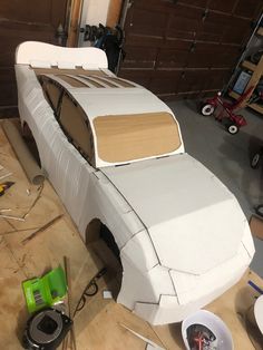 a car made out of cardboard sitting on top of a wooden table