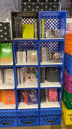 the shelves are filled with many different colored books and binder folders on them