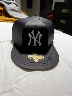 a new york yankees hat sitting on top of a bed