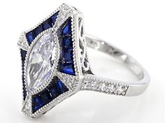 Bella Luce ® 3.86ctw lab created blue spinel and white diamond simulant 3.86ctw round, marquise, and baguette rhodium over sterling silver ring. Measures approximately 13/16"L x 1/16"W and is not sizeable. Art Deco Blue Cubic Zirconia Rings, Blue Cubic Zirconia Art Deco Rings, White Sapphire Ring With Diamond Accents In Cubic Zirconia, White Sapphire Cubic Zirconia Ring With Gemstone, White Cubic Zirconia Sapphire Ring, White Sapphire Ring With Cubic Zirconia Gemstone, White Sapphire Ring With Cubic Zirconia, Blue Marquise Cut Jewelry With Diamond Accents, Art Deco Blue Cubic Zirconia Jewelry