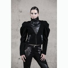 Introducing our Battle Angel Jacket, a striking embodiment of avant-garde fashion and street high fashion. Crafted for the fashion-forward, this winter jacket boasts a unique blend of quality wool felt and faux leather, ensuring warmth and style are perfectly balanced. Designed with practicality in mind, this jacket features pockets and a lining for added comfort. The high collar adds an edgy touch, while the standout feature is the puffed sleeves, setting it apart in the realm of black clothing Fitted Black Biker Jacket For Alternative Fashion, Cyberpunk Fitted Winter Outerwear, Winter Cyberpunk Fitted Outerwear, Fitted Cyberpunk Winter Outerwear, Fitted Black Punk Biker Jacket, Futuristic Winter Outerwear For Cosplay, Black Biker Jacket For Alternative Fashion In Winter, Fall Cyberpunk Outerwear For Alternative Fashion, Edgy Black Outerwear For Alternative Fashion