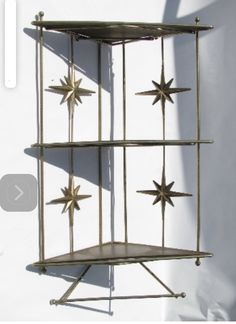 a metal shelf with three star decorations on it's sides against a white wall