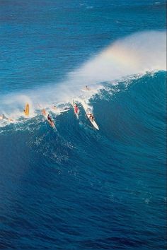 several surfers are riding the waves on their surfboards in the ocean with blue water