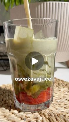 a glass filled with ice cream and strawberries on top of a wicker table