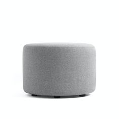 a grey ottoman sitting on top of a white floor