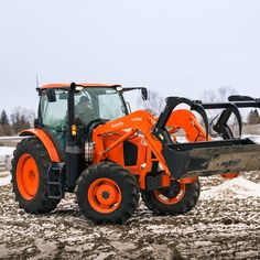 an orange tractor is parked in the snow