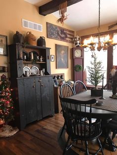 a dining room table and chairs with christmas decorations on the wall in front of it