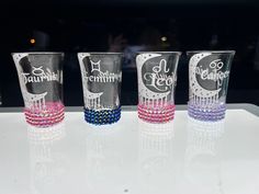 three shot glasses with beaded bands on them