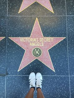 a person standing in front of a star on the hollywood walk of fame with their feet up