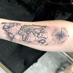 a man's arm with a world map tattoo on it