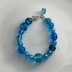 Discover the beauty of our Crystal Blue Lamp Work Glass Bead Bracelet, a mesmerizing piece of handcrafted jewelry that adds a touch of elegance to any ensemble. Each glass bead is skillfully crafted with intricate details, showcasing the captivating shades of crystal blue that catch the light beautifully. 🌟 Handcrafted Elegance 🌟 Indulge in the artistry of this lamp work glass bead bracelet, lovingly handcrafted to create a one-of-a-kind accessory. The combination of exquisite craftsmanship and alluring crystal blue hues makes this bracelet a true statement piece.🛍️ Product Details 🛍️ Material: Lamp Work Glass Beads Bead Color: Crystal Blue Bracelet Length: Adjustable to fit most wrists Clasp: Secure Toogle Clasp Crystal Blue Bracelet, Lamp Work Glass Bead Jewelry, Handcrafted Accessor Bohemian Blue Czech Glass Bracelets, Adjustable Light Blue Jewelry With Spacer Beads, Blue Czech Glass Bracelets With Colorful Beads, Blue Crystal Bracelet With Colorful Beads, Blue Czech Glass Bracelets With Spacer Beads, Blue Crystal Bracelet With Faceted Beads, Blue Bohemian Crystal Bracelet With Round Beads, Elegant Blue Bead Bracelet, Elegant Blue Hand-strung Crystal Bracelet