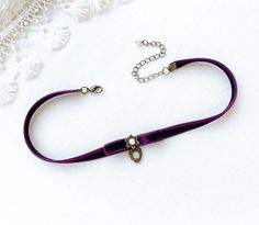 This eye-catching choker necklace is handmade with a soft double faced eggplant purple velvet ribbon. It features a velvet bow, a pearl bead jewel and a small bronze filigree heart charm with a sparkling rhinestone. See last photo for other colors available separately in the Rosy Posy Designs shop. Brides... I can make several choker necklaces for your bridesmaids. Contact me for custom designs in your wedding colors and style. * Size ~ Adjustable length 12 - 15 inches with extender chain Please Purple Choker Necklace For Gift, Fair Festival, Rosy Posy, Purple Choker, Necklace Girlfriend, Filigree Heart, Beaded Jewels, Ribbon Necklace, Eggplant Purple