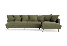 a green sectional couch with pillows on it's back and arms, in front of a white background