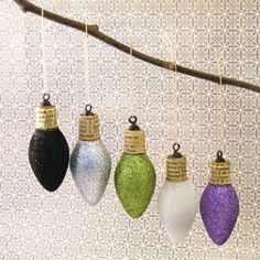 christmas ornaments hanging from a tree branch with measuring tape on them and colored glass ornament