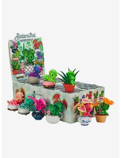 a table topped with potted plants on top of a white table covered in cartoon characters