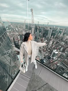 a woman standing on top of a tall building