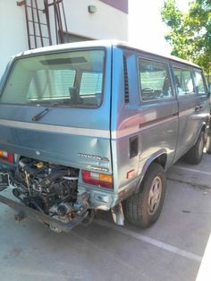 the front end of a van that is parked in a parking lot next to another vehicle