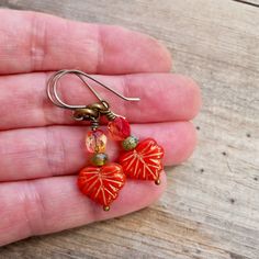 "These beaded dangle earrings are sure to add a pop of color to your wardrobe. They are just stunning! These earrings are 1.5\" in length. The smaller beads are 3 x 5mm. The leaf bead is 10 x 13mm. The ear wire shown on the earrings is a commercially made antique brass wire or titanium. If you order titanium, the ear wire is handmade. To find other items in this series, try this link. https://www.etsy.com/shop/CraftLikeAnArtist?ref=l2-shopheader-name&search_query=autumn+series16 Titanium is Titanium Earrings, Orange Earrings, Norma Jean, Fall Earrings, Yellow Earrings, The Leaf, Themed Jewelry, Beaded Dangle Earrings, Pretty Earrings