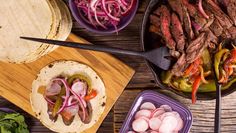 several different types of food are being prepared on a wooden table with utensils