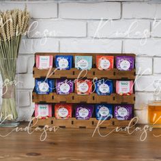 a wooden crate filled with soaps next to a vase full of flowers and a jar of honey