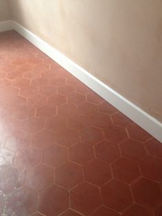 an empty room with red tile flooring and white walls