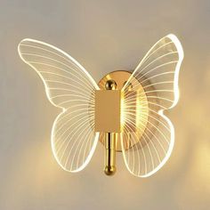 a light that is on the wall with a butterfly shaped light in front of it