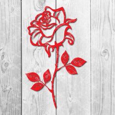 a red paper cutout of a rose on a white wooden background