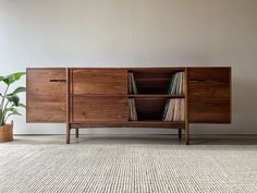 the sideboard is made out of wood and has records on it's shelves