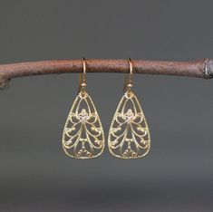 "Beautifully detailed shiny gold vermeil filigree triangle drop charms simply dangle from gold vermeil balled earwires. These incredibly lightweight go-with-everything earrings complete any outfit for daytime or evening. Gold charms: 15x24mm Total length of earrings: 1 3/8\" All gold is 18k vermeil. As the owner, maker, designer, and curator of this shop, I take great pride in providing you with jewelry that you will love to wear everyday, for special occasions, and for many years to come. Pleas Gold Filigree Chandelier Earrings For Anniversary, Dainty Gold Earrings With Elegant Design, Gold Teardrop Earrings With Elegant Design As A Gift, Gold Filigree Sterling Silver Chandelier Earrings, Gold Sterling Silver Filigree Chandelier Earrings, Gold Filigree Teardrop Earrings For Formal Occasions, Elegant Brass Teardrop Earrings With French Hook, Gold Dangle Teardrop Earrings With Elegant Design, Elegant Teardrop Earrings With French Hook In Brass