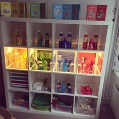 a book shelf filled with lots of books next to a wall covered in magnets