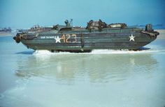 an army boat is traveling through the water